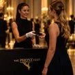 A guest checking in her phone with a gloved attendant